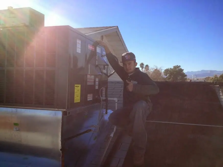 HVAC technician performing Air Duct Cleaning on a rooftop unit in Federal Heights